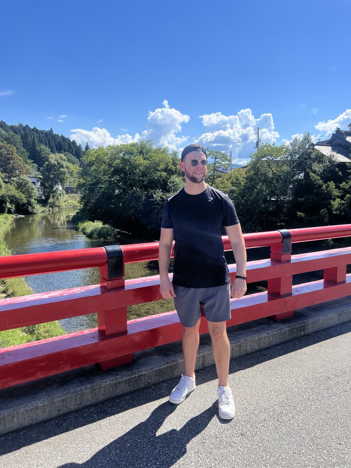 Mike McGreary standing on a red bridge beside a river