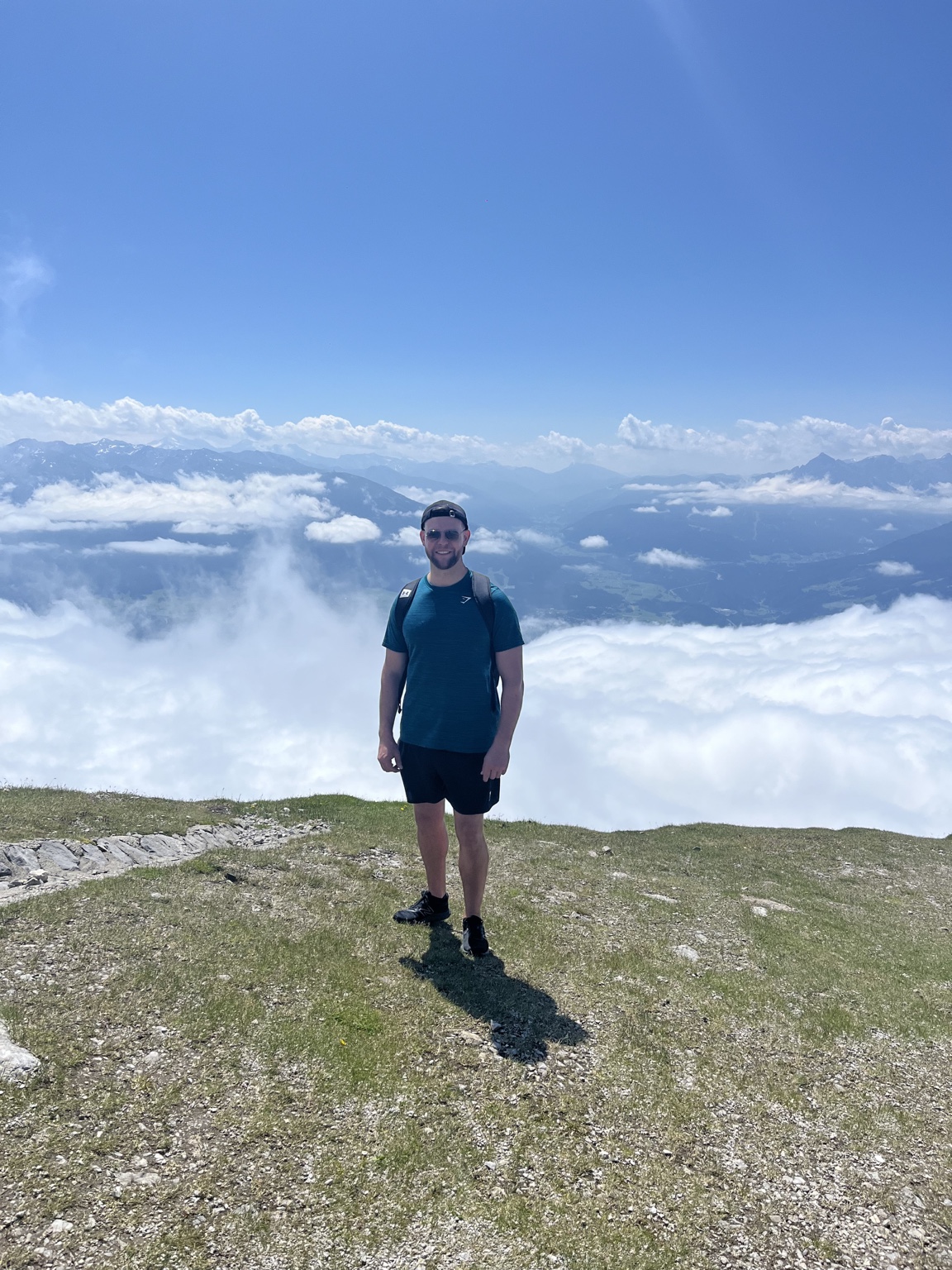 Dr Mike McGreary standing on a mountain summit above the clouds